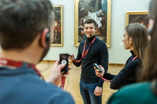 wireless-tour-guide-system-in-use A tour guide using a Chierda wireless tour guide system to communicate with her group in a museum.